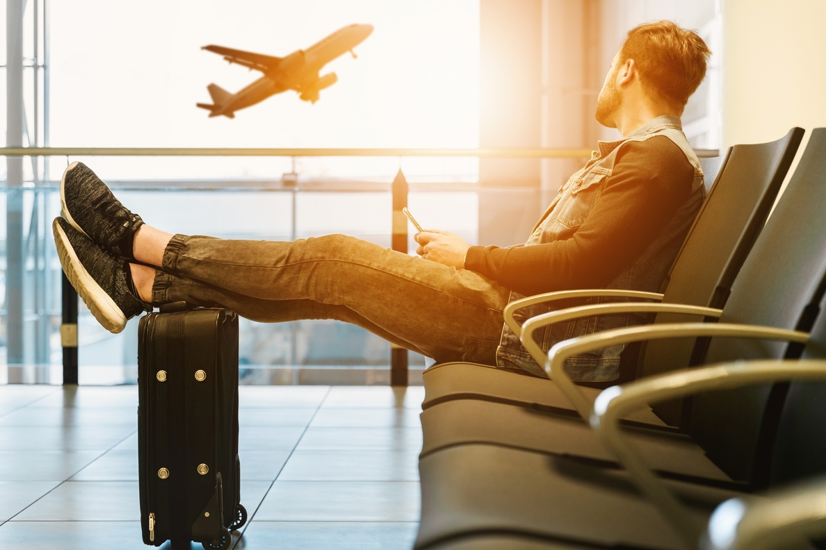 man sitting at the airport on Thanksgiving watching a plane